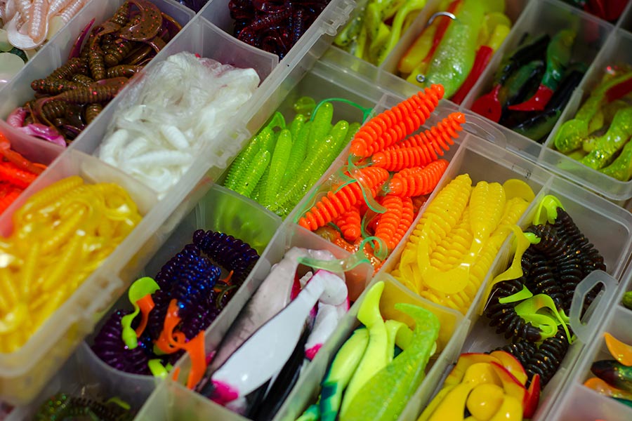 Various multicolored soft fish baits in a box