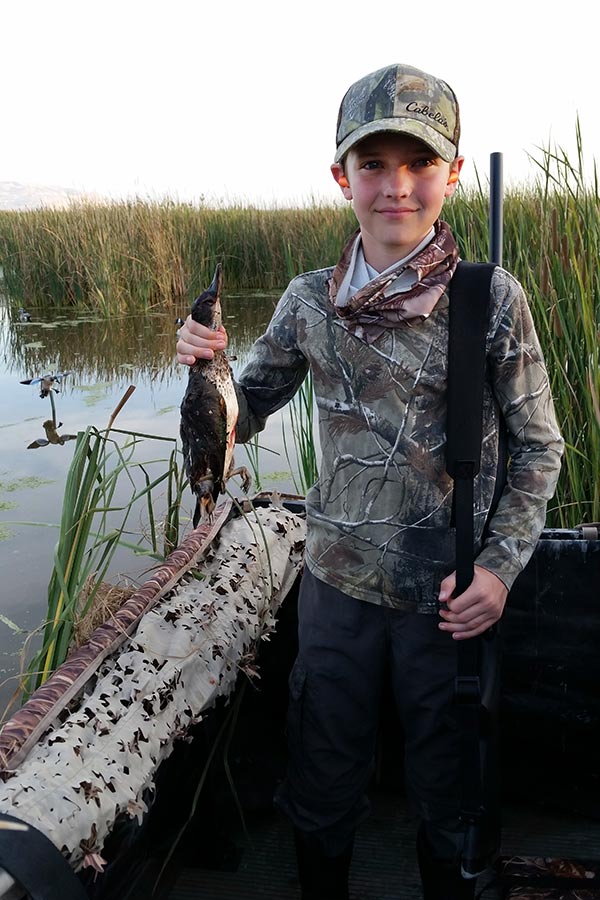Boy hunter holding a harvested duck at Farmington Bay