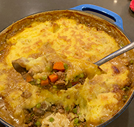Spoonful of freshly cooked elk and mushroom cottage pie in a pot