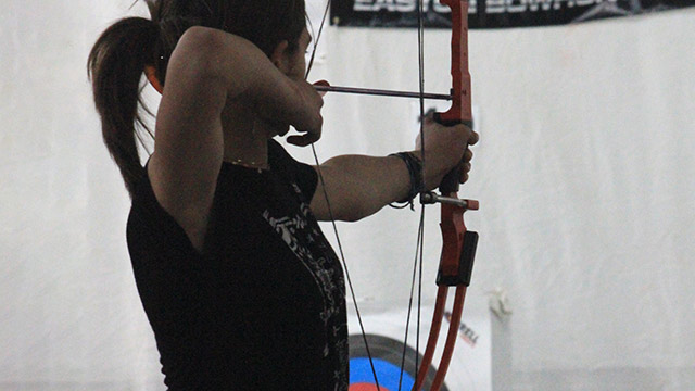 Young female archer shooting an arrow
