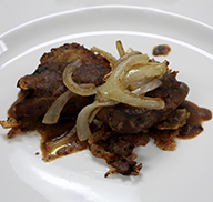 Pan-fried elk liver sprinkled with onions on a plate
