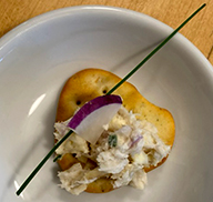 Smoked trout rillettes served with a piece of radish on a cracker