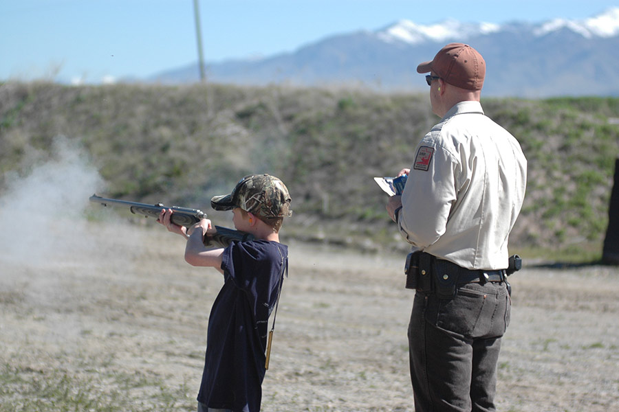 Instructor with child shooting gun